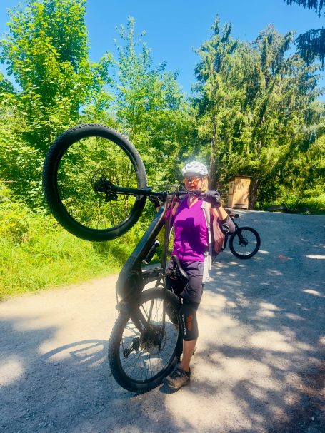 E-MTB Camp Ultental 2026 E-MTB-Fahrerin übt das kontrollierte Anheben des Vorderrads auf einem schattigen Waldweg im Ultental.