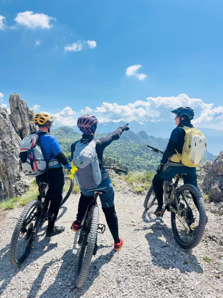 E-MTB Camp Gardasee 2026 Drei E-MTB-Fahrerinnen stehen mit ihren Bikes an einem felsigen Aussichtspunkt am Tremalzopass nahe dem Gardasee.