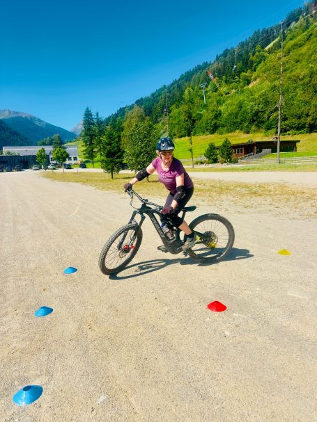 E-MTB Camp Ultental 2026 E-MTB-Fahrerin trainiert Kurventechnik zwischen farbigen Markierungshütchen auf einem Übungsplatz im Ultental.